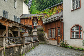 Historic watermill and Saint John statue in Austrian alley
