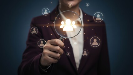 Businesswoman using magnifying glass to highlight human icons for hr or recruitment, marketing strategy, ad performance