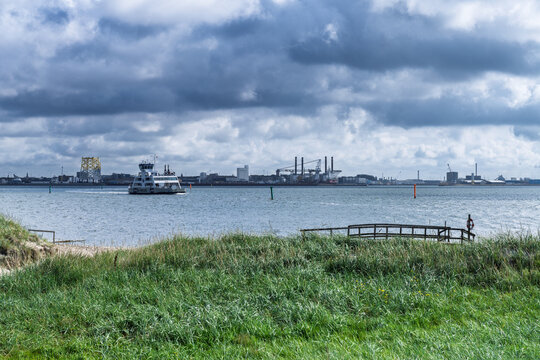 Coastal Ferry on Calm Water Near Industrial Harbor Skyline Under Moody Clouds, Esbjerg, Fano, Denmark