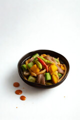 Colorful stir fried vegetables in a dark bowl