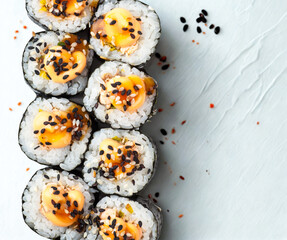 Delicious sushi rolls topped with sesame seeds and sauce