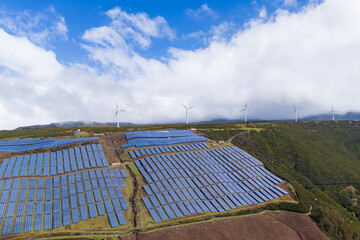 Solar panel and a wind turbine on Madeira island, eco-friendly energy system. Aerial view