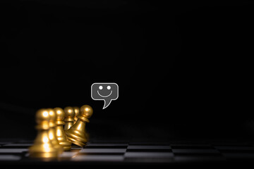 Golden chess pawns with one smiling speech bubble above a tilted piece, symbolizing individuality, communication, motivation, positive mindset, leadership, and standing out from the crowd.