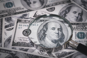 Magnifying glass focusing on US dollar bills represents financial analysis, money inspection, currency validation, and business auditing. Ideal for finance, banking, and investment themes.