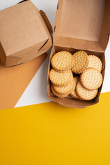 Cookies in a craft box on a light background. Homemade cookies in eco-friendly packaging. Composition for branding, delivery, or catering concepts. Sweet snack.
