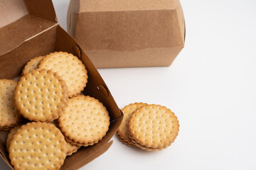 Cookies in a craft box on a light background. Homemade cookies in eco-friendly packaging. Composition for branding, delivery, or catering concepts. Sweet snack.