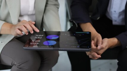 Businesswoman examining various financial charts and graphs displayed on a tablet, engaging in a discussion of market trends and investment strategies. - Powered by Adobe