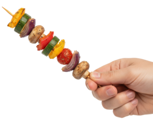 a hand holds a grilled vegetable skewer with zucchini, peppers, and mushrooms