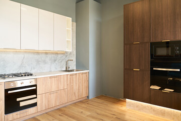 Modern kitchen featuring a sleek black gas oven and wooden cabinets