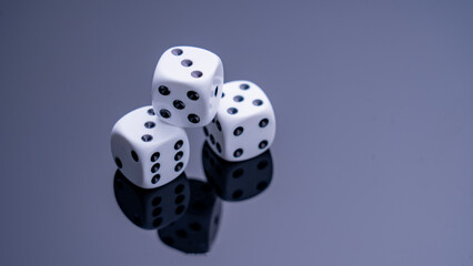 A close-up view of black and white dice on a dark, reflective surface. The dice represent chance, fortune, danger, and decision-making. They are perfect for games, strategic planning, or discussions