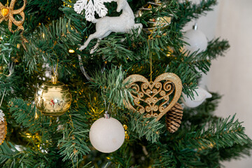 A golden heart on a branch of a Christmas tree. Christmas decorations.