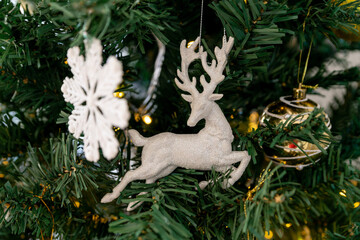 A white deer on a branch of a Christmas tree. Christmas decorations.
