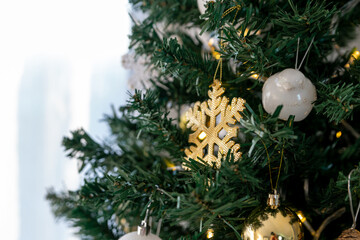 A golden snowflake on a branch of a Christmas tree. Christmas decorations.