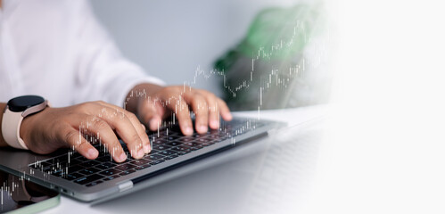 Businessman Typing on Laptop with Financial Data and Stock Market Graph