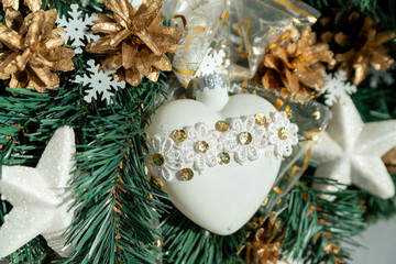 A white heart on a Christmas wreath made of spruce.  Christmas decorations
