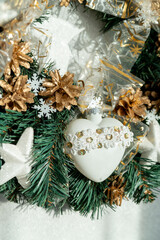 A white heart on a Christmas wreath made of spruce.  Christmas decorations