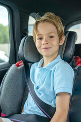 Little boy sitting on the seat car security looking at camera.