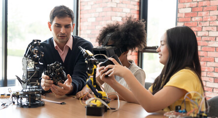 Home school concept. Male teacher teaching children training and learning robotics technology in classroom at school. Students training AI robot training kit and mechatronics in class