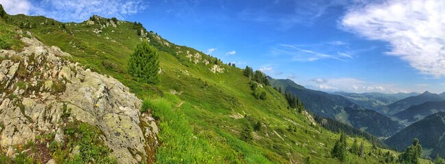 Panoramic view of a lush green mountain landscape under clear skies