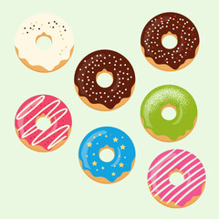 Assortment of colorful glazed doughnuts on light green background