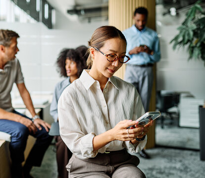 Portrait of a group of young business people having a meeting in the office. Teamwork and success concept, portrait of a smart young businesswoman using a smartphone phone and texting