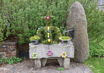 Village stone fountain decorated for the traditional Easter holidays (Bavaria, Germany)