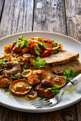 Fried saffron milk cap mushrooms with fresh salad and bread on wooden table	