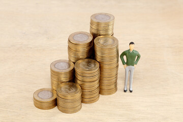 Stack of coin and businessman figurine - Concept of money investment and growth