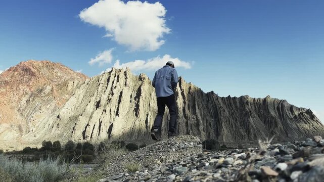 rear view of an asian photographer working in the field taking a photo of a mountain, xinjiang, china