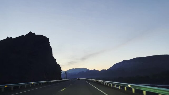 vehicle traveling on dark winding road, in mountainous area, xinjiang, china