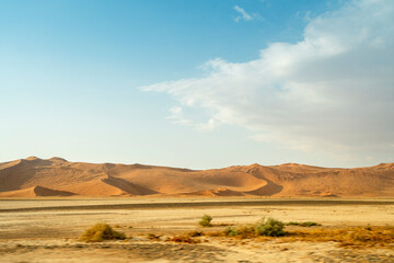 Rolling desert dunes near North Windhoek, Namibia, stretch beneath a dramatic cloudy sky