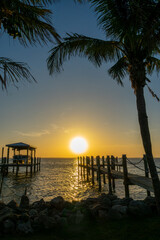 Fototapeta premium Boat pier and palm trees, sunset landscape on the Banana River in Cocoa Beach, Florida