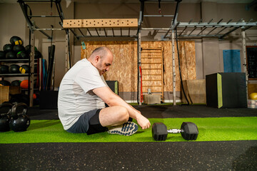 Man resting on green gym floor during workout