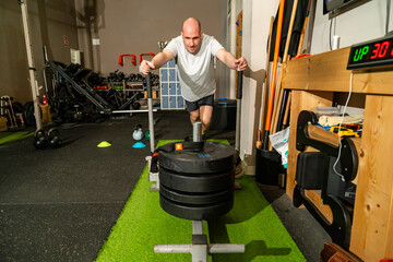 Man pushing heavy sled during strength training workout