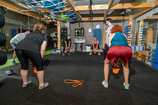 Adults training with kettlebells in a gym class