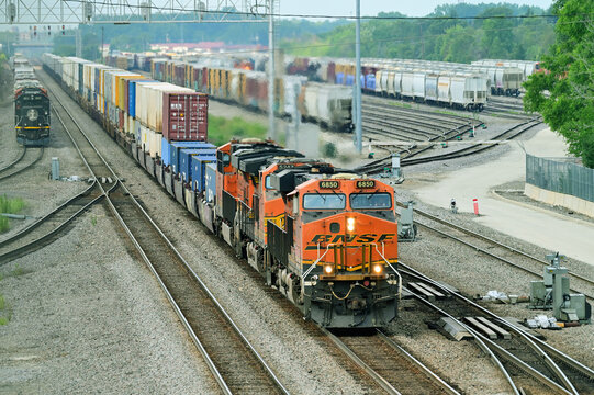 A Burlington Northern Santa Fe container train passing through a BNSF railraod yard in the far western suburbs of Chicago destined for the city.