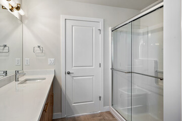 Bathroom with a white door and a glass shower