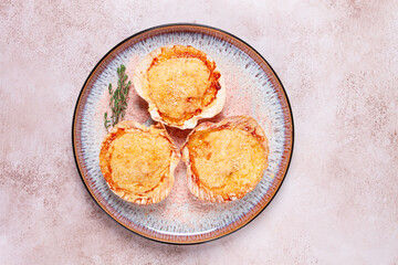 scallop, baked in shells, with cheese and spices, on a plate, homemade,