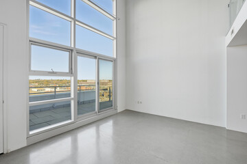 Large, empty room with a large window overlooking a city