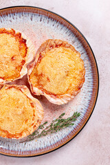 scallop, baked in shells, with cheese and spices, on a plate, homemade,