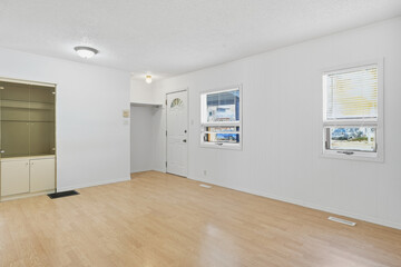 Large, empty room with a white door and windows