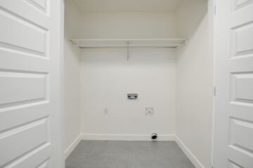 Small, empty room with a white door and a white wall