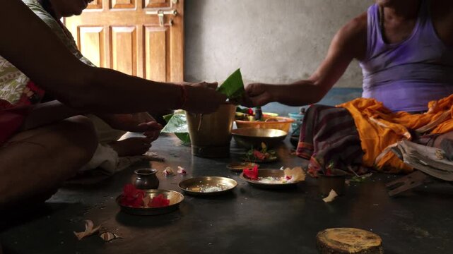 Close-up of Shivling pooja with milk, flowers, and bael leaves being offered. Indian people performing sacred havan on the occasion of Mahashivratri, offering ghee to the holy fire during  Vedic puja.