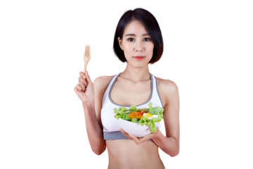 Healthy young woman in sportswear holding a bowl of fresh salad and wooden fork on pink background, promoting clean eating and healthy lifestyle concept.