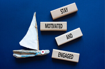 Stay Motivated and Engaged symbol. Concept words Stay Motivated and Engaged on wooden blocks. Beautiful deep blue background. Business concept. Copy space
