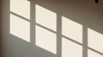 Soft natural window light and shadow patterns cast across a wall creating a calming and serene ambient overlay effect for design projects.