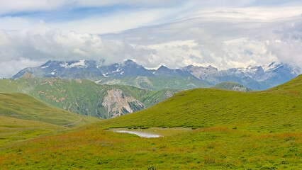 Obraz premium green alpine landscape under a cloudy sky in La Vanoise nature reserve, Savoie, France 
