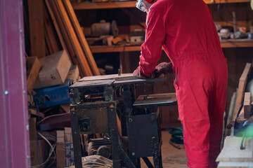 A man is sawing a board with a circular saw.