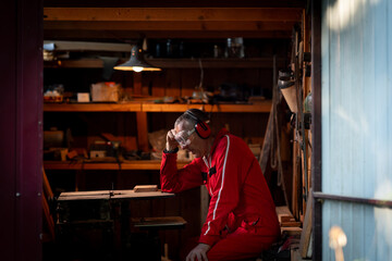 A tired man sits in his workshop.