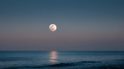 Full moon rising over the ocean at dusk, reflecting on the water's surface
